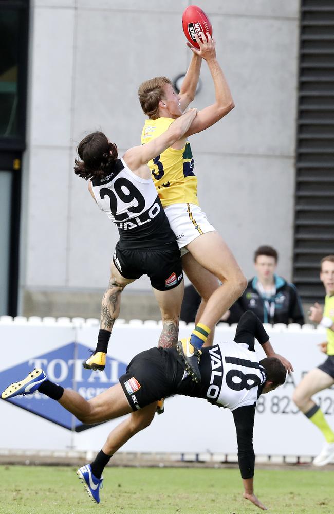 Jack Lukosius takes a big mark over Jasper Pittard and Jimmy Toumpas. Picture: Sarah Reed