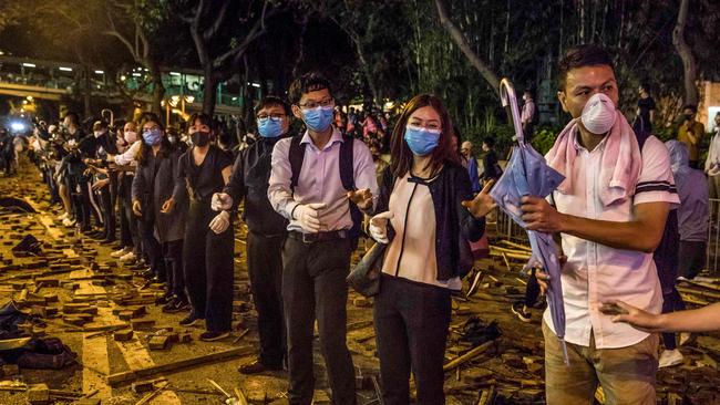 Protesters form a human chain to pass items to the frontline during clashes with police yesterday at the Hong Kong Polytechnic University. Picture: AFP