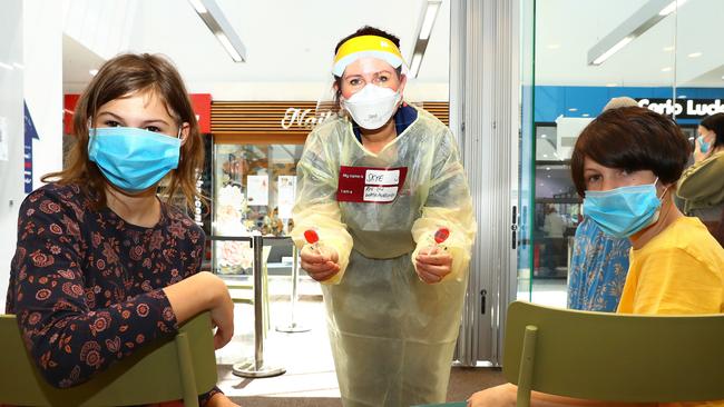 Wathaurong RN Skye Duncan hands out lolly pops after giving sisters Destiny and Sapphire Collett their Covid vaccination at Corio Village Shopping Centre. Picture: Alison Wynd