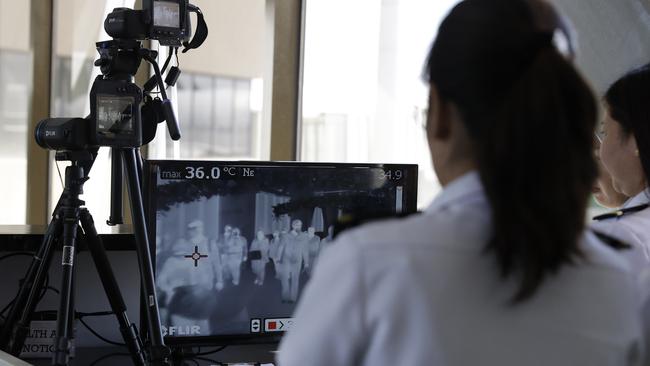 Airports around the world have taken to using thermal scanners in order to screen passengers on arrival. The technology pictured is being used at Manila's international airport, Philippines. Picture: AP/Aaron Favila