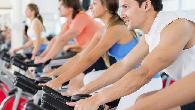 Group of people in a spinning class a the gym