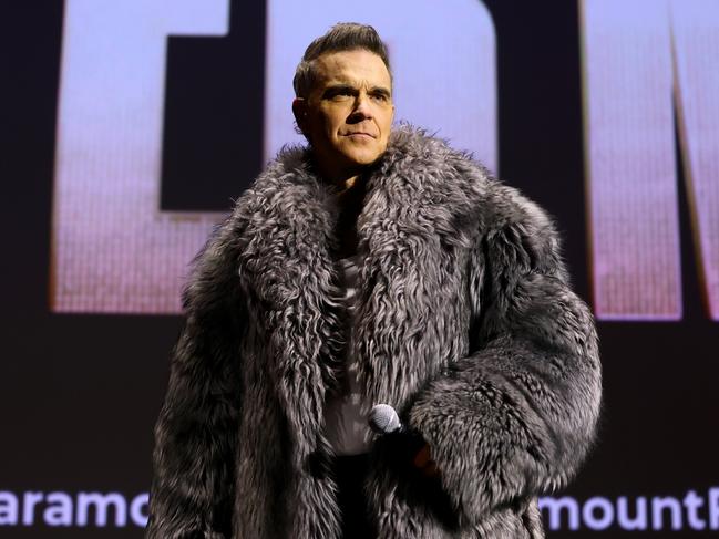 PARIS, FRANCE - DECEMBER 13: Robbie Williams speaks on stage during the "Better Man" special screening at  on December 13, 2024 in Paris, France. (Photo by Marc Piasecki/Getty Images for Paramount Pictures)