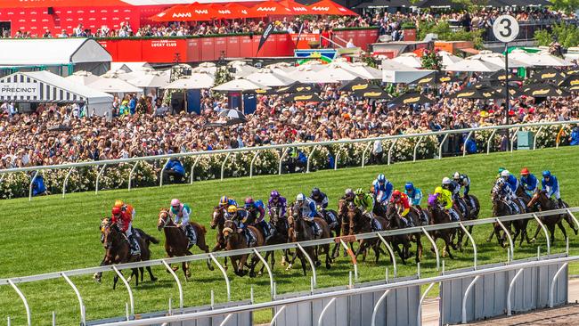 The Melbourne Cup field in action in front of a huge crowd at Flemington. Picture: Jason Edwards