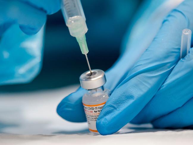 (FILES) In this file photo taken on November 24, 2021 a nurse prepares the Pfizer-BioNTech Covid-19 vaccine for children for distribution in Montreal, Quebec. - Canada's Quebec province announced February 1, 2022 it was scrapping plans for a health tax on those who are not vaccinated against Covid-19, following a public backlash over the proposal. (Photo by Andrej Ivanov / AFP)