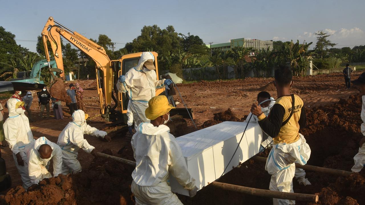 Gravediggers wearing personal protective equipment carry a coffin for burial at a cemetery in Bekasi on July 12, 2021, as Indonesia faces its most serious outbreak. Picture: AFP