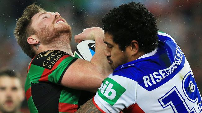 Chris McQueen of Souths tackled by Chanel Mata'utia during the Souths v Knights game.