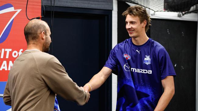 Kangaroos youngster Wil Dawson receives his jumper from champion Ben Cunnington. Picture: Dylan Burns/AFL Photos via Getty Images