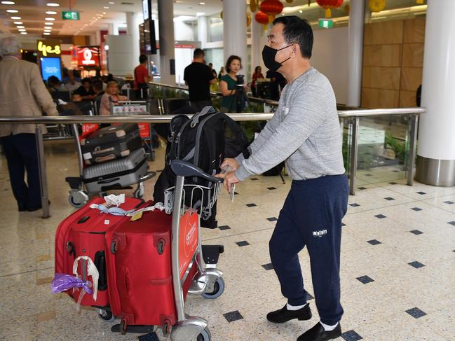 A passenger wears a protective mask on arrival at Sydney International Airport. Picture: AAP/Joel Carrett