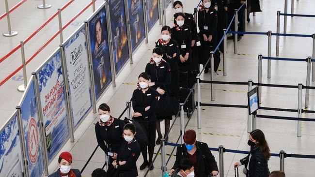 Airline staff and passengers wait to be screened at John F. Kennedy Airport as a federal judge in Florida struck down the mask mandate for airports and other methods of public transportation. Picture: AFP.