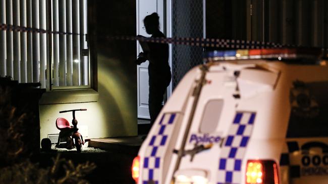 A tricycle is illuminated by the light of a forensic police officer in the doorway of the house. Picture: Ian Currie