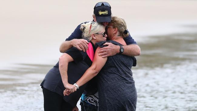 Tweed Heads tourism business owner Trevor Arbon (centre) and residents are seen at a vigil for a murdered nine-month-old girl. They are at Jack Evans Harbour where the homeless family had camped out. (AAP Image/Jason O'Brien)