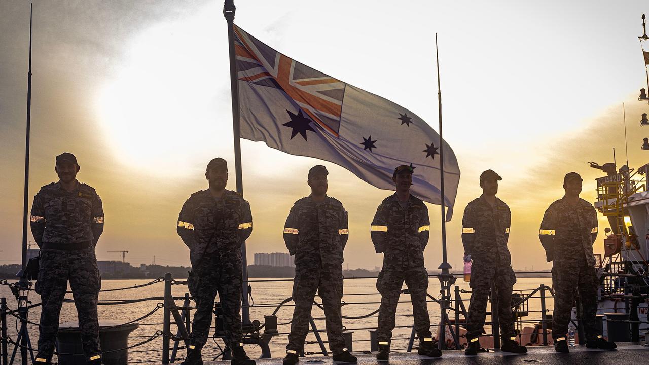 Personnel from HMAS Hobart line the flight deck as the ship departs the port of Sembawang, Singapore. Picture: Royal Australian Navy