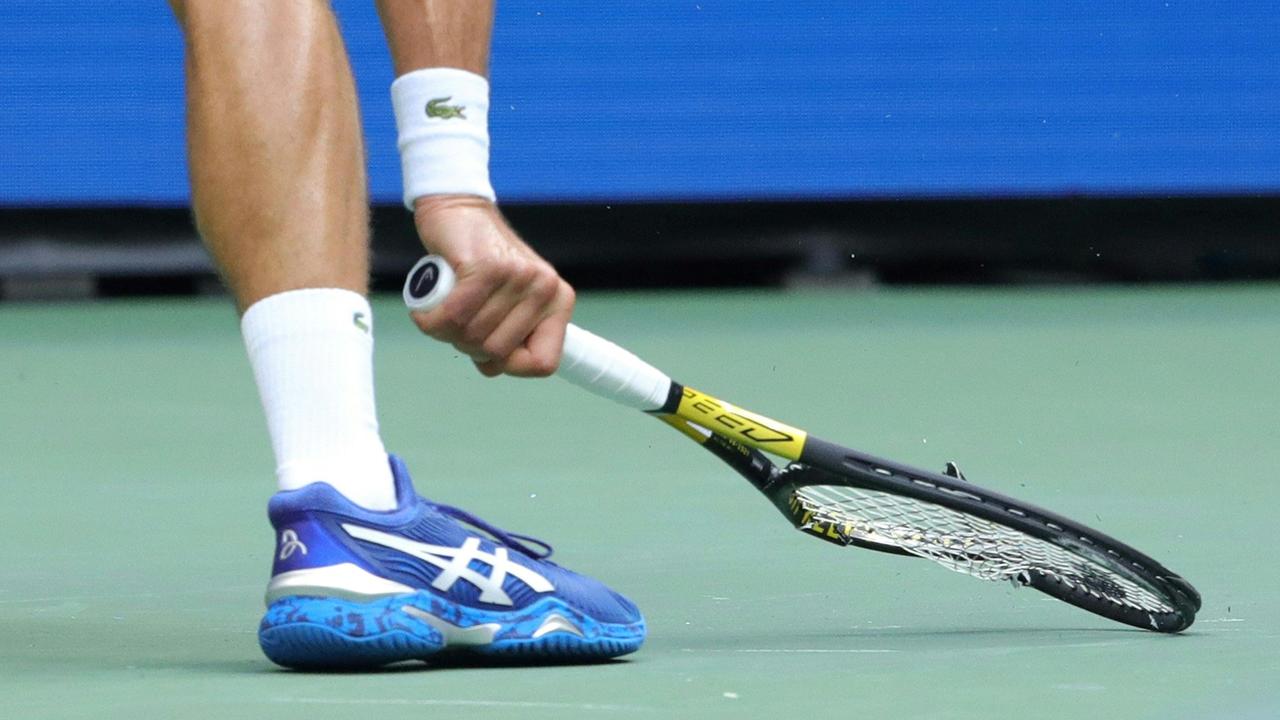 Novak Djokovic of Serbia smashes his racquet. Photo by Kena Betancur / AFP.