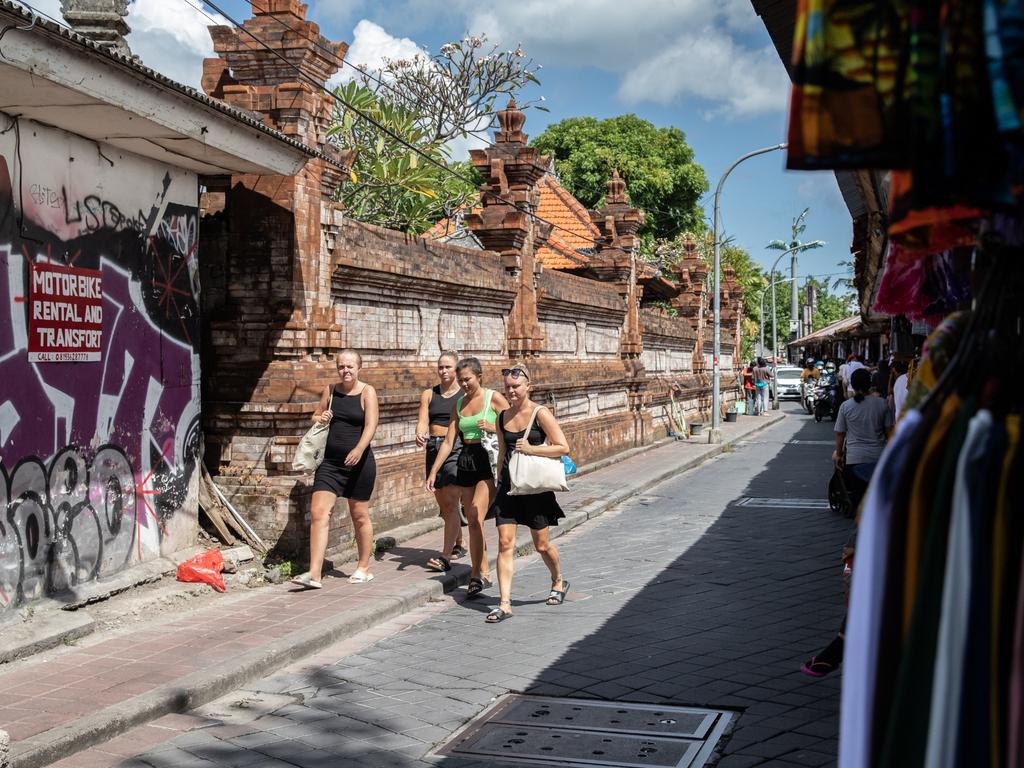 Foreign tourists walk past clothing stores in Kuta, Bali, Indonesia. Picture: Putu Sayoga/Bloomberg via Getty Images