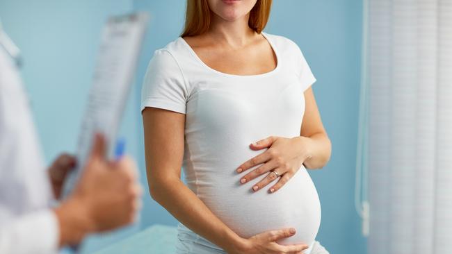 Pregnant woman with hands on stomach talking to obstetrician Picture: Istock