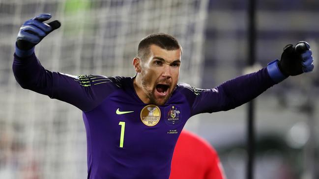 Mat Ryan celebrates saving a shot in the penalty shootout against Uzbekistan.