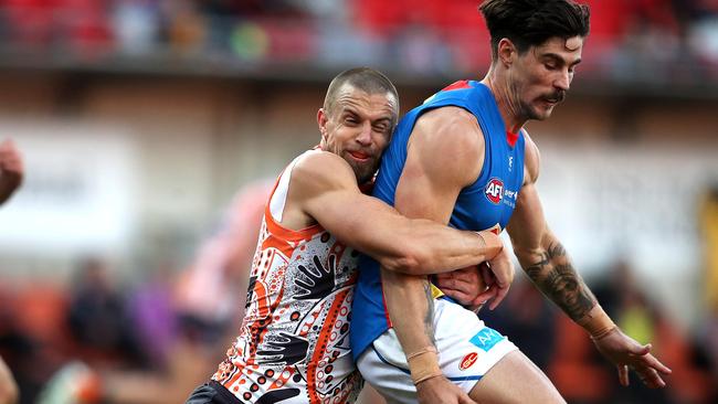 Brett Deledio wraps up Gold Coast forward Alex Sexton in a big tackle. Picture: Phil Hillyard.