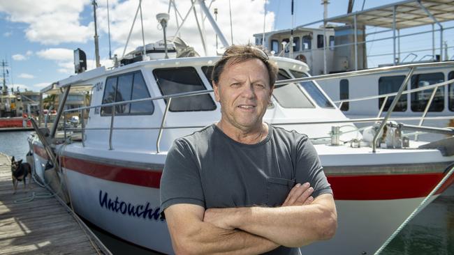 Les Polkinghorne skipper of Untouchable with his crayfish boat and dog Robbie docked at Lincoln Cove Marina. Picture: Mark Brake