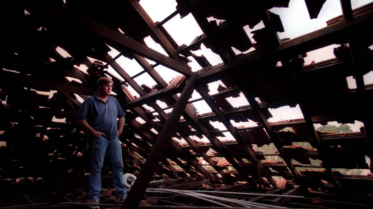 Sydney resident Greg Moore and destroyed attic roof following a freak overnight hailstorm that destroyed roofs, car windscreens and cut power to homes 15 Apr 1999. hail storm /Storms
