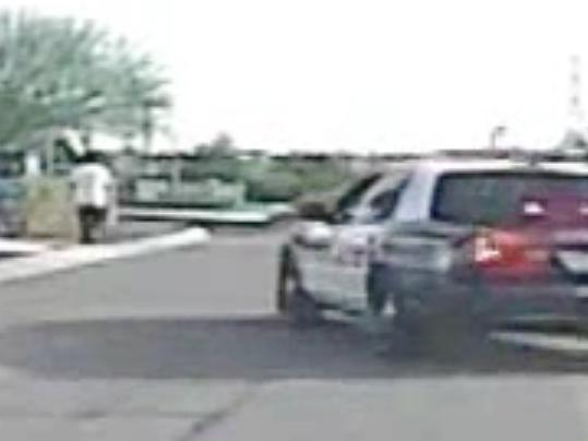 In this Feb. 19, 2015, frame from a dash cam video provided by the Marana Police Department, police vehicles near Mario Valencia in Marana, Ariz. Dramatic dash cam video released Tuesday, April 14 shows a police officer using his cruiser to ram the armed suspect, Valencia, sending him flying in the air before the car smashes into a wall. Valencia survived the crash, and prosecutors cleared the officer of any wrongdoing. (Marana Police Department via AP)