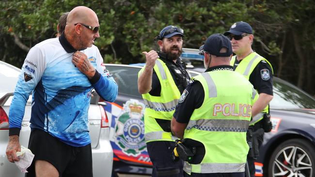 Police conducting traffic stops as a part of ‘Operation Oculus’ on Oxley Drive, Paradise Point. An alleged Finks bikie walks away after receiving a fine. Picture Glenn Hampson