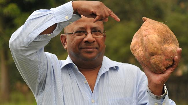 Lawrence Machado with the giant sweet potato he grew in his garden. Picture: Jake McCallum