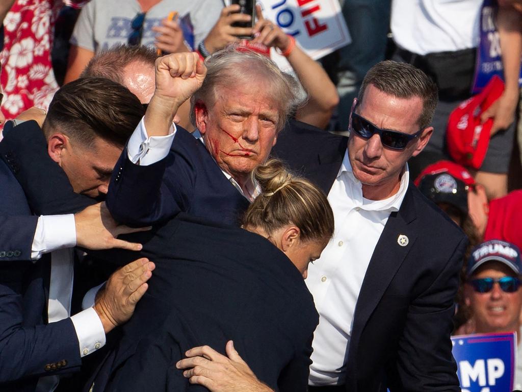 Donald Trump is seen with blood on his face surrounded by secret service agents as he is taken off the stage at a campaign event in Pennsylvania. Picture: Rebecca Droke/AFP