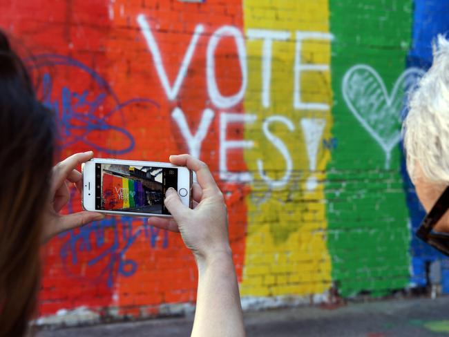 People take photos of a Vote Yes mural supporting same-sex marriage in Sydney. Picture: AFP