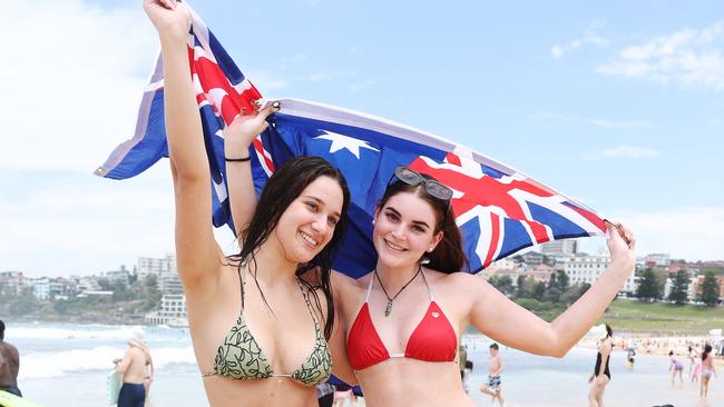 Angelina Blazevski and Kristy Larkin proudly flying the Australian flag on Bondi Beach. Picture: Rohan Kelly