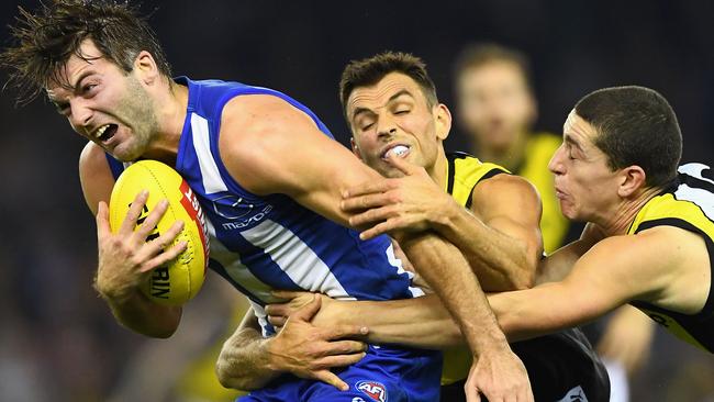 Tigers Sam Lloyd and Jason Castagna put Luke McDonald under the pump.