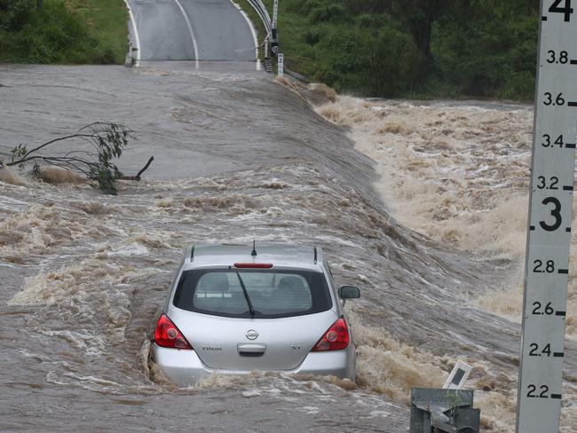 A car caught in floodwaters at Clagiraba Weir. The driver was rescued from his roof by a local. Picture Glenn Hampson