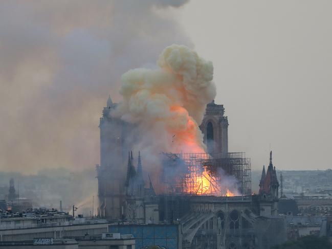 Flames and smoke are seen billowing from the roof at Notre-Dame Cathedral in Paris on April 15, 2019. (Photo by LUDOVIC MARIN / AFP)