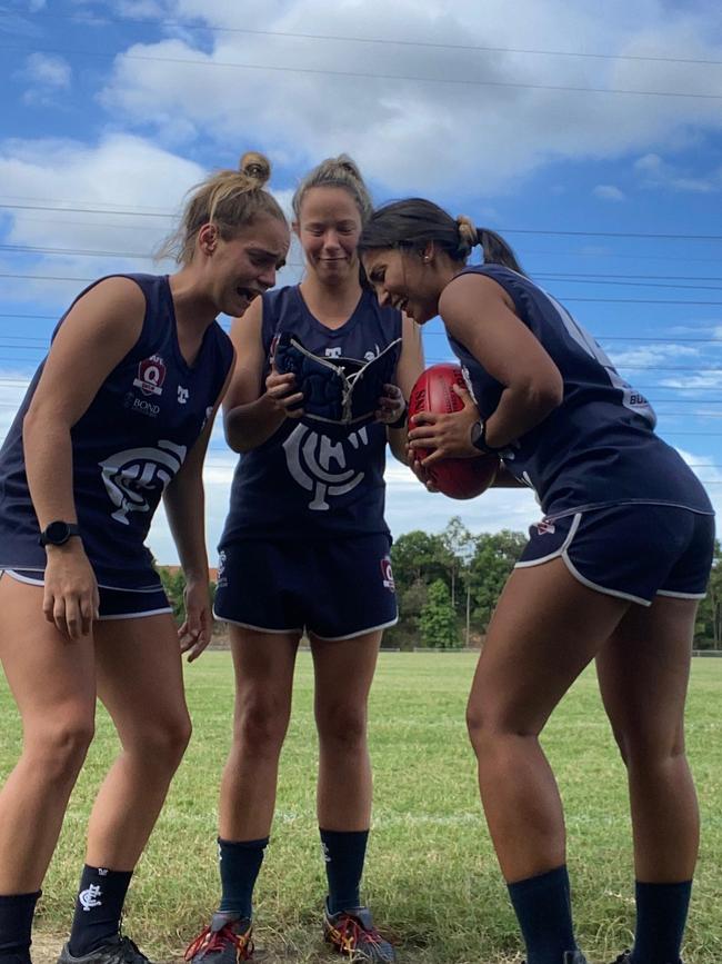 Ebony Peterson (right) and Jannifer Gomes (left) smell Lauren Jame's helmet (centre). SUPPLIED.