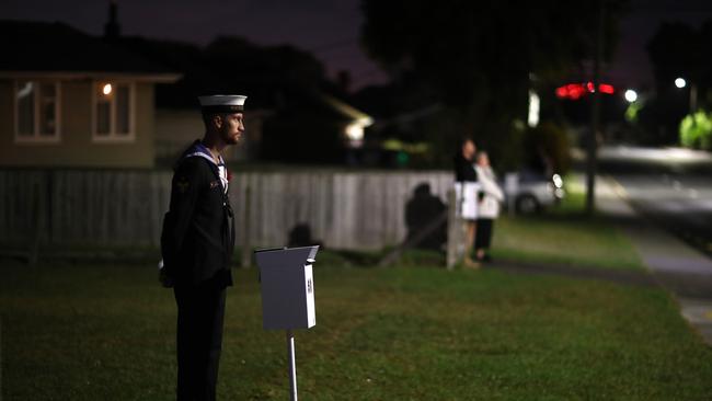 Able Marine Technician Troy Pemberton pays his respects at dawn at the end of his driveway in Auckland, NZ. Picture: Getty