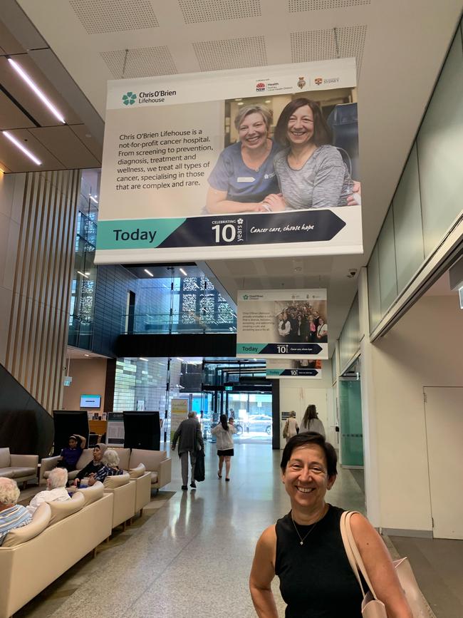 Toni Korsanos beneath a sign of her when she was undergoing treatment at Chris O’Brien Lifehouse.