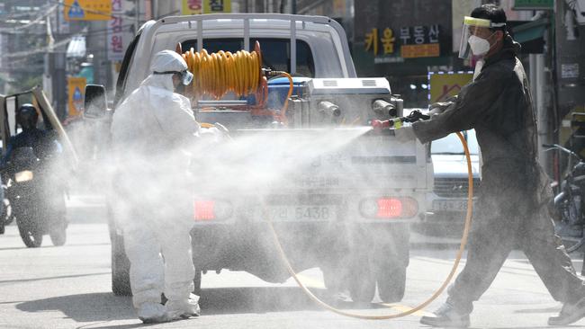 A health official sprays disinfectant on the street near the Sarang Jeil Church, a new coronavirus infection cluster, in Seoul on Tuesday. Picture: AFP