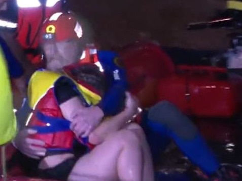 WATCH: Woman clings to a tree in raging floodwaters