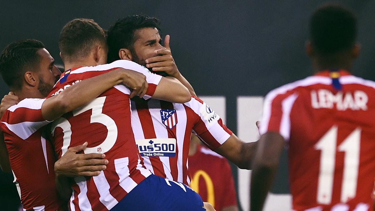 Atletico Madrid's Brazilian forward Diego Costa (C) celebrates one of his four goals against Real Madrid. (Photo by Johannes EISELE / AFP)