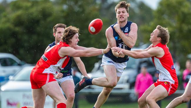 Launceston’s Tim Jones handballs before being tackled by Clarence players Sam Green and James Holmes. Picture: SOLSTICE DIGITAL