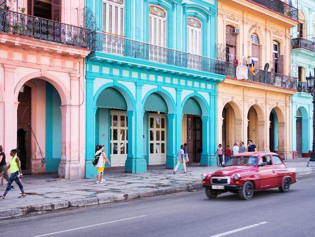 Havana, Cuba - April 18, 2016: Classic vintage car and colorful colonial buildings in the main street of Old Havana