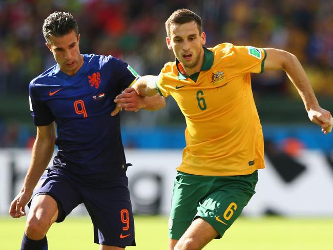 Matthew Spiranovic takes on Robin Van Persie at the 2014 World Cup.