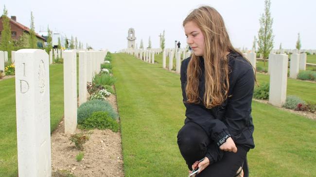 Megan Cridland from Maitland in NSW at Villers Bretonneux in northern France yesterday where she turned 17 years old as she comes across the headstone of a relative ahead of Anzac Day. Picture: Charles Miranda