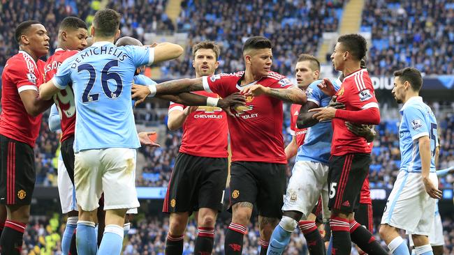 Manchester United and City players argue.