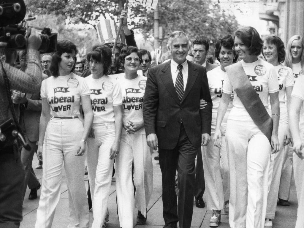 Former Liberal Leader Sir Billy Snedden walking to an election rally in the Adelaide Town Hall, escorted by 10 young women.