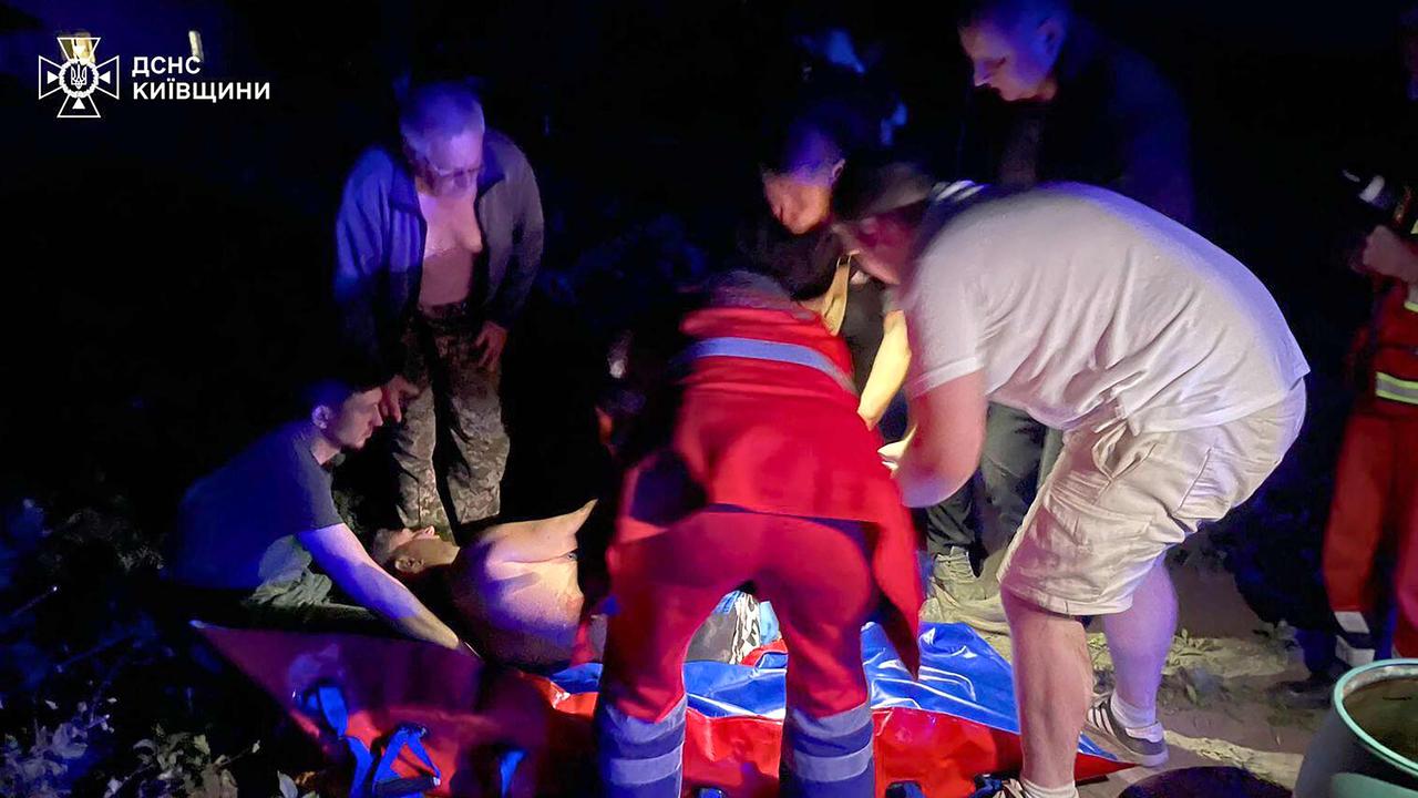 Rescuers and locals help an injured person following Russian strikes in Kyiv. Picture: AFP.