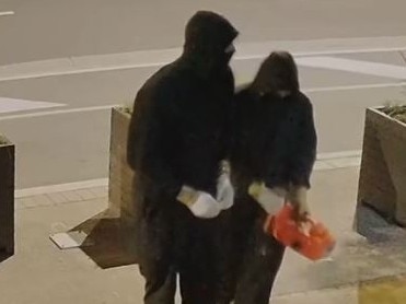 Two hooded figures could be seen pouring liquid accelerant over the front of the business on Christmas morning. Picture: VicPol