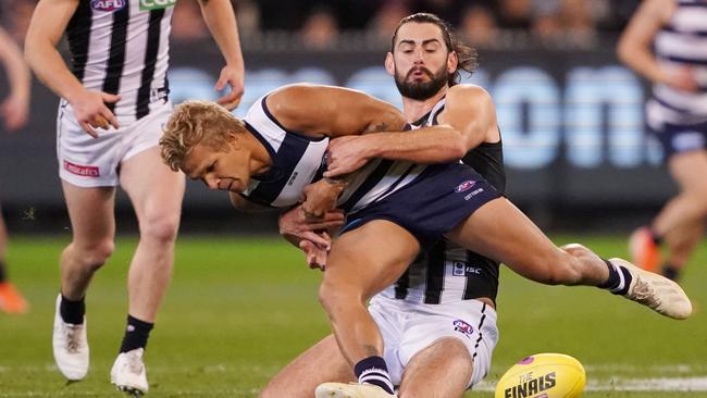 Quinton Narkle is wrapped up by Collingwood ruckman Brodie Grundy. Picture: AAP Image/Michael Dodge.