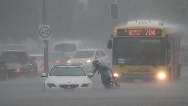 A cyclist makes their way through the flood water. Picture: Jason O'Brien