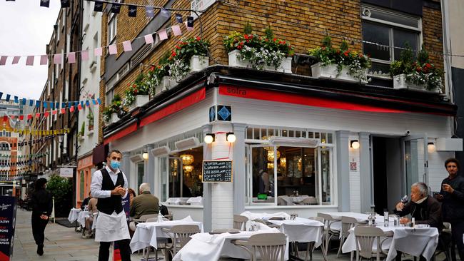 A waiter wearing works at a recently reopened restaurant in central London. Picture: AFP.