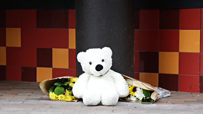 Flowers and a teddy left outside the Riverwood apartment block where a three-year-old boy was found stabbed to death. Picture: Adam Yip